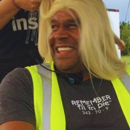 Recon Marine John Keller wearing a blonde wig on a movie set with 9/11 Remember Til Ya Die t-shirt.