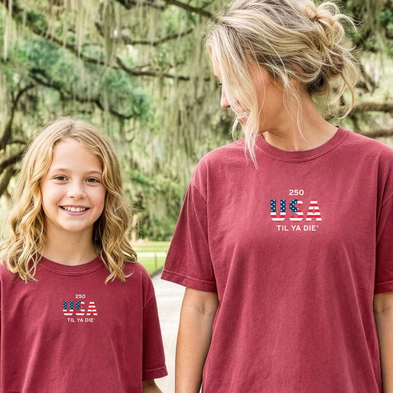 Two people wearing matching red t-shirts with USA Til Ya Die on the front of the Nola Til Ya Die tee.