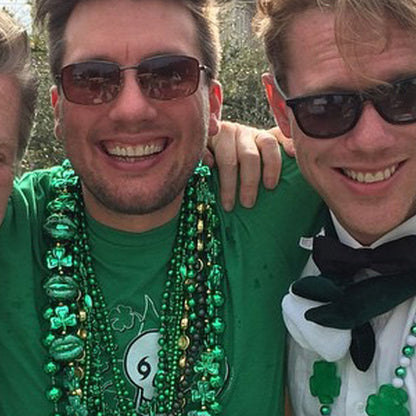 Three men celebrating St. Patrick's Day in the New Orleans Irish Channel parade with green beads and a NOLA Til Ya Die Irish t-shirt.